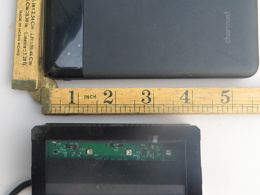 A picture of the GemLight Super, next to a battery pack and ruler, indicating its' size to be approx 10cm